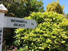 A sign pointing to Wonwell Beach with foliage at Park Cottage in Kingsbridge