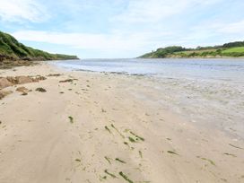 A beach with sand and water at Park Cottage in Kingsbridge