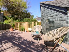 An outdoor patio with chairs and a table at Park Cottage Kingston, Kingsbridge