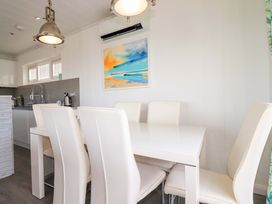 A dining room with a table and chairs and kitchen appliances at 114 - The Residance in Redruth