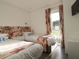 A bedroom with two beds and a television at 114 - The Residance Redruth