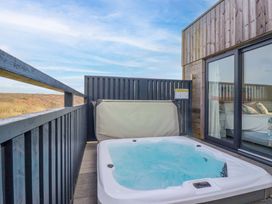 An outdoor area with a hot tub and sliding glass doors at 114 - The Residence in Redruth