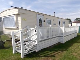 A caravan with steps and a railing at Whispering Meadows - 104 Great Yarmouth