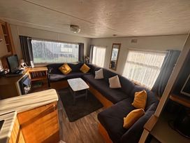 A living room with a sofa and coffee table at Whispering Meadows - 104 Great Yarmouth