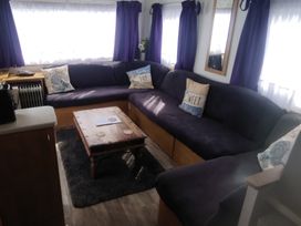 A living room with a sofa and coffee table at Whispering Meadows - 104 Great Yarmouth