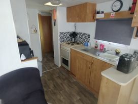 A kitchen with a stove and sink at Whispering Meadows - 104 Great Yarmouth