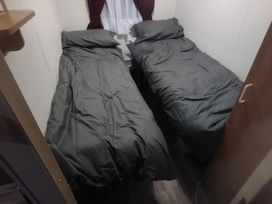 A bedroom with two beds and a window at Whispering Meadows - 104 Great Yarmouth