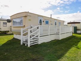 A mobile home with steps and a fence at Whispering Meadows - 104 Hemsby