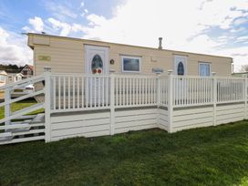 A mobile home with a porch and stairs at Whispering Meadows - 104 Hemsby