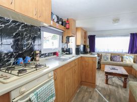 A kitchen with cabinets and a stove at Whispering Meadows - 104 Hemsby