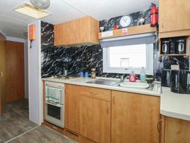 A kitchen with cabinets and appliances at Whispering Meadows - 104 Hemsby