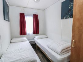 A bedroom with twin beds and a window at Whispering Meadows - 104, Hemsby