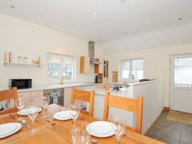 A kitchen with a table and chairs at Cribba in Port Isaac