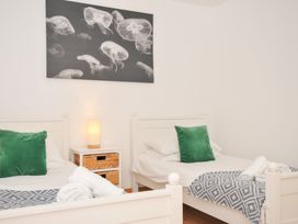 A bedroom with two beds and a lamp at Cribba in Port Isaac