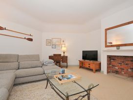 A living room with a sofa, table, and television at Cribba in Port Isaac