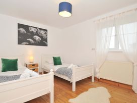A bedroom with two beds and a lamp at Cribba in Port Isaac