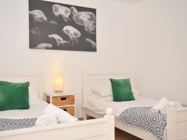 A bedroom with two single beds and a lamp at Cribba in Port Isaac