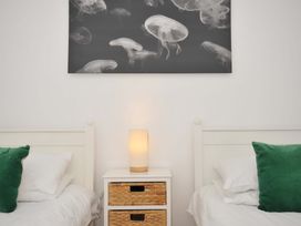 A bedroom with two beds and a nightstand at Cribba in Port Isaac