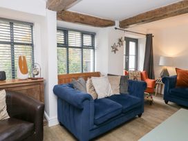 A living room with a blue sofa and armchairs at No.2 The Flags in Grange-over-Sands
