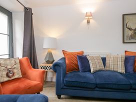 A living room with a blue sofa and orange armchair at No.2 The Flags, Grange-over-Sands