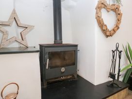 A wood stove with decorations and tools in a living room at No.2 The Flags, Grange-over-Sands