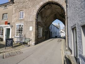 An archway with shopfront on one side and road leading through at No.2 The Flags, Grange-over-Sands