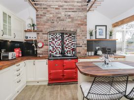 A kitchen with a red stove and wooden countertop at No.2 The Flags in Cartmel