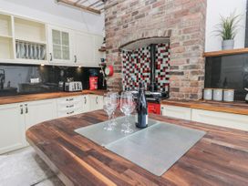 A kitchen with wine glasses and bottles on the counter at No.2 The Flags Cartmel