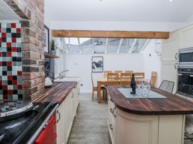 A kitchen with an island and dining table at No.2 The Flags in Cartmel