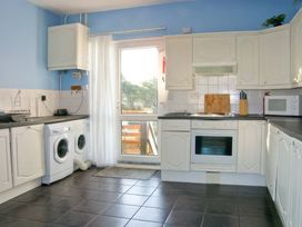 A kitchen with appliances and cabinets at Morlais in Rhosneigr