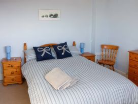 A bedroom with a bed and bedside tables at Morlais in Rhosneigr