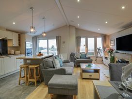 A living room with a sofa and TV at Serenity Lodge in Wemyss Bay