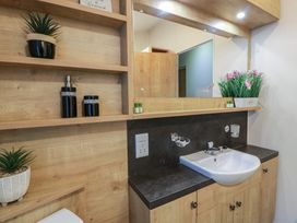 A bathroom with a sink and mirror at Serenity Lodge in Wemyss Bay