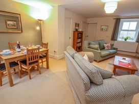 A living room with a dining area and a sofa at Easthwaite Cottage in Holmrook near Easthwaite Farm