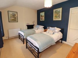 A bedroom with two beds and wall art at Easthwaite Cottage in Holmrook near Easthwaite Farm