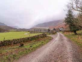A barn and stone wall along a gravel road at Easthwaite Cottage Holmrook near Easthwaite Farm