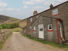 A house exterior near a dirt path at Easthwaite Cottage in Nether Wasdale near Wastwater