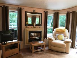 A living room with a television and a recliner chair at Plot 293 Caravan in 