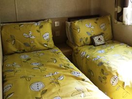 A bedroom with two beds and decorative pillows at Plot 293 Caravan