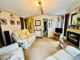 A living room with sofas and television at Plot 293 Caravan Weybourne near Sheringham