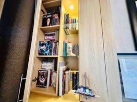 A bookshelf with DVDs and books at Plot 293 Caravan Weybourne near Sheringham