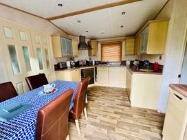A kitchen with a table and chairs at Plot 293 Caravan Weybourne near Sheringham