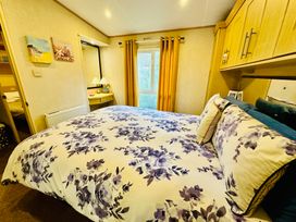 A bedroom with a bed and dresser at Plot 293 Caravan Weybourne near Sheringham