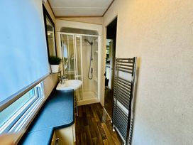 A bathroom with a shower and sink at Plot 293 Caravan Weybourne near Sheringham