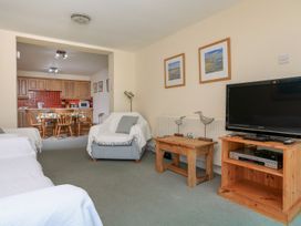 A living room with a television and seating area at 3 The Salcombe in Salcombe