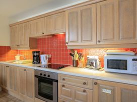 A kitchen with wooden cabinets and appliances at 3 The Salcombe in Salcombe