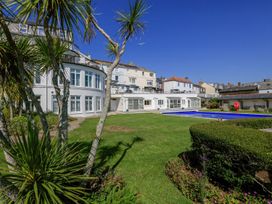 An outdoor area with a swimming pool and palm trees at 3 The Salcombe Salcombe