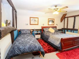 A bedroom with two beds and wooden beams at Driftway Stables Retreat in Diss