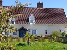 A house with a fence and palm tree at Driftway Stables Retreat in Diss