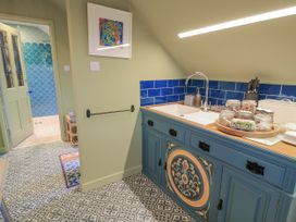 A kitchen with a sink and blue tiles at Golden Valley View, Stroud